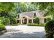 Charming brick home features an inviting covered entryway, a brick driveway and mature landscaping at 1016 Old Powers Ferry Rd, Atlanta, GA 30327