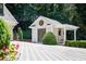Detached garage with unique architectural details and a driveway leading to the main house at 1016 Old Powers Ferry Rd, Atlanta, GA 30327