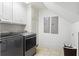 Well-equipped laundry room with modern washer and dryer, white cabinetry, and ample storage space at 1016 Old Powers Ferry Rd, Atlanta, GA 30327