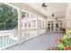Spacious covered porch with multiple ceiling fans overlooking a swimming pool and green backyard at 1016 Old Powers Ferry Rd, Atlanta, GA 30327