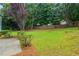 Large green backyard surrounded by mature trees and wooden fence at 3807 Lance Bluff Ct, Duluth, GA 30097