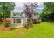 Back exterior of the home with a patio, windows, and lush green lawn at 3807 Lance Bluff Ct, Duluth, GA 30097