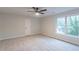 Bedroom with neutral colored walls, carpeted floors, a large window, and a door at 3807 Lance Bluff Ct, Duluth, GA 30097