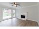 Cozy living room with a fireplace, ceiling fan, and hardwood floors at 3807 Lance Bluff Ct, Duluth, GA 30097