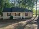 Charming single-story home with a welcoming front porch, surrounded by lush trees and natural beauty at 796 Cohran Store Rd, Douglasville, GA 30134