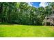 Spacious backyard featuring a lush green lawn and mature trees at 8040 Banks Mill Rd, Douglasville, GA 30135