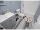 Bathroom featuring gray vanity with storage and a tiled shower, complete with a baseball-themed rug at 8040 Banks Mill Rd, Douglasville, GA 30135