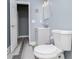 Bathroom featuring gray vanity, toilet, and wood look flooring, next to an open door at 8040 Banks Mill Rd, Douglasville, GA 30135
