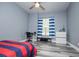 Well-lit bedroom with gray walls and a ceiling fan, complemented by gray and brown flooring at 8040 Banks Mill Rd, Douglasville, GA 30135