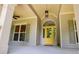 Inviting front porch featuring a vibrant yellow door and decorative accents at 8040 Banks Mill Rd, Douglasville, GA 30135