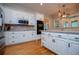 A well-lit kitchen featuring white cabinetry, stainless steel appliances and hardwood floors at 8040 Banks Mill Rd, Douglasville, GA 30135