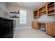 Spacious laundry room with washer, dryer, desk, and upper wood cabinets at 8040 Banks Mill Rd, Douglasville, GA 30135