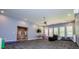 Open living room with a ceiling fan, carpeting, large windows, and modern paint colors at 8040 Banks Mill Rd, Douglasville, GA 30135