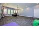 Spacious room with a ceiling fan, carpeting, large windows, and modern paint colors at 8040 Banks Mill Rd, Douglasville, GA 30135
