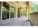 Expansive porch with wood flooring, ceiling fans, and views of the wooded outdoors at 8040 Banks Mill Rd, Douglasville, GA 30135