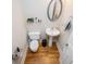 Compact powder room with wood flooring, pedestal sink, and oval mirror at 8040 Banks Mill Rd, Douglasville, GA 30135