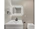Updated half bath with a modern vanity, sleek faucet, and lighted mirror at 847 Magna Carta Nw Dr, Atlanta, GA 30318
