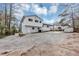 A two-story home featuring white siding, a brick foundation and large driveway with a shed in the back at 847 Magna Carta Nw Dr, Atlanta, GA 30318