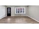 A bright, empty living room featuring hardwood floors, fresh paint, and a large window overlooking the front yard at 847 Magna Carta Nw Dr, Atlanta, GA 30318