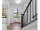 Bright entryway featuring wood flooring, a staircase with dark metal railings, and a view of the outdoors at 102 Brackley Dr, Cumming, GA 30040