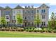 Charming three-story townhome with brick exterior, manicured lawn and landscaping, and a dark metal fence at 102 Brackley Dr, Cumming, GA 30040