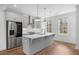 Modern kitchen with stainless steel appliances, gray cabinets, island, and bright windows at 102 Brackley Dr, Cumming, GA 30040