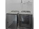 Laundry room equipped with gray front load washer and dryer and a wire rack shelf above at 102 Brackley Dr, Cumming, GA 30040