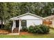 Charming single-story home with white siding, a black front door, and a well-maintained, tree-lined yard at 1947 Main St, Atlanta, GA 30318
