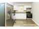 Contemporary kitchen featuring stainless steel appliances, granite countertops, and white cabinetry with hardwood flooring at 1947 Main St, Atlanta, GA 30318