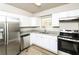 Modern kitchen with stainless steel appliances, white cabinets, granite counters, and hardwood flooring at 1947 Main St, Atlanta, GA 30318