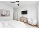 A cozy bedroom features a TV, sitting chair and stool, a bed and light hardwood flooring at 332 Gibson Se St, Atlanta, GA 30316