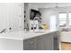 Kitchen island featuring gray cabinetry, white countertops, stainless steel sink, and views of the living area at 332 Gibson Se St, Atlanta, GA 30316
