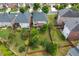 Aerial view of a home's backyard with a deck, green lawn, mature trees, and garden areas at 812 Autry Oak Ct, Alpharetta, GA 30022