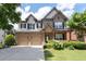 Charming two-story brick home featuring a two-car garage, landscaped yard, and covered front porch at 812 Autry Oak Ct, Alpharetta, GA 30022