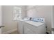 Bright laundry room features a washer, dryer, wire shelving and a window for natural light at 812 Autry Oak Ct, Alpharetta, GA 30022