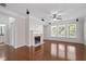 Open living room with hardwood floors, fireplace, large windows, and view into other rooms at 812 Autry Oak Ct, Alpharetta, GA 30022