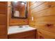 Bathroom featuring wood paneled walls, and stone framed mirror at 1552 Brentwood Dr, Marietta, GA 30062