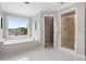 Large bathroom with soaking tub, and glass shower with gold trim at 1552 Brentwood Dr, Marietta, GA 30062