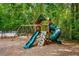A colorful playground with a slide, climbing wall, and swings, surrounded by lush greenery and trees at 1552 Brentwood Dr, Marietta, GA 30062