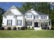 Inviting two-story home boasts a manicured lawn, tasteful landscaping, and a classic white facade with dark blue accents at 1895 Henley Way, Alpharetta, GA 30009