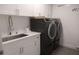 Laundry room with modern washer and dryer, sink, and sleek white cabinets, combining function and style at 1895 Henley Way, Alpharetta, GA 30009