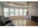 Living room features a home movie theater setup with a leather couch, hardwood floors, and bright windows at 1895 Henley Way, Alpharetta, GA 30009