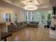 Spacious living room with hardwood floors, coffered ceiling, large windows, and a comfortable sectional sofa at 1895 Henley Way, Alpharetta, GA 30009