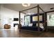 Spacious main bedroom with four-poster bed, hardwood floors, and a sitting area with fireplace at 1895 Henley Way, Alpharetta, GA 30009