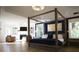 Luxurious main bedroom suite featuring a cozy sitting area with fireplace, four poster bed, and ample natural light at 1895 Henley Way, Alpharetta, GA 30009