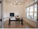 Bright home office with a glass-top desk, modern lighting, and large windows at 1895 Henley Way, Alpharetta, GA 30009