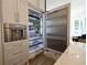 Built-in refrigerator with stainless steel interior and beverage center in custom kitchen cabinetry at 1895 Henley Way, Alpharetta, GA 30009