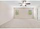 Bright bedroom featuring neutral carpet, two windows with blinds, and a ceiling fan with lighting at 522 Spring View Dr, Woodstock, GA 30188