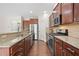 Well-equipped kitchen with granite countertops, stainless steel appliances, and dark wood cabinets for ample storage at 522 Spring View Dr, Woodstock, GA 30188