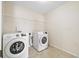 Convenient laundry room with modern appliances, shelving, and tile flooring at 522 Spring View Dr, Woodstock, GA 30188